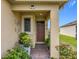 Inviting front porch featuring potted plants, stylish decor, and a brick walkway at 3449 Meadow Beauty Way, Clermont, FL 34714