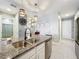 Stylish kitchen island with pendant lights, granite countertops, and stainless steel dishwasher; nearby bathroom at 3449 Meadow Beauty Way, Clermont, FL 34714