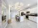 Bright kitchen with white cabinetry, granite counters, an island with barstool seating, and stainless steel appliances at 3449 Meadow Beauty Way, Clermont, FL 34714