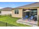 Cozy patio featuring outdoor chairs, an umbrella, and a BBQ grill, perfect for relaxing in the backyard at 3449 Meadow Beauty Way, Clermont, FL 34714