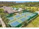 Aerial view of the tennis and pickleball courts, next to the pool, clubhouse and a playground at 3449 Meadow Beauty Way, Clermont, FL 34714