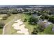 Aerial view of houses beside a golf course with sand traps and lush green fairways at 3720 Eversholt St, Clermont, FL 34711