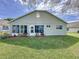 Back exterior of home with well-maintained lawn and small shrubs at 3720 Eversholt St, Clermont, FL 34711