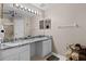 Bathroom featuring double vanity, granite countertops, vanity mirror, and towel rack at 377 Ed Douglas Rd, Groveland, FL 34736