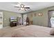 Bright main bedroom features carpet, ceiling fan, furniture, and walk-in closet at 377 Ed Douglas Rd, Groveland, FL 34736