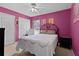 Cozy bedroom with bright pink walls, carpet flooring, and a ceiling fan at 377 Ed Douglas Rd, Groveland, FL 34736