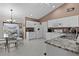 Open kitchen with granite countertops, white cabinetry, and stainless steel appliances at 377 Ed Douglas Rd, Groveland, FL 34736