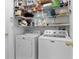 Bright laundry room with white Maytag washer and dryer, shelving, and ample storage space at 377 Ed Douglas Rd, Groveland, FL 34736