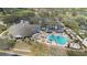 Aerial perspective of a community pool area featuring a hot tub, lounging areas, and lush surroundings at 4256 Fawn Meadows Cir, Clermont, FL 34711