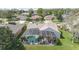 Aerial view of a home featuring a screened in pool, lush yard and mature trees at 4256 Fawn Meadows Cir, Clermont, FL 34711