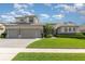 Well-manicured lawn, three-car garage, and pristine home exterior under a blue sky at 4256 Fawn Meadows Cir, Clermont, FL 34711