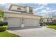 Large three-car garage with stone accents and a well-maintained driveway at 4256 Fawn Meadows Cir, Clermont, FL 34711