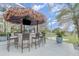 This outdoor bar is a perfect place to entertain with its covered tiki hut, grill, and ample seating at 4256 Fawn Meadows Cir, Clermont, FL 34711