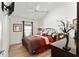 Cozy bedroom featuring warm wood floors, white walls, ceiling fan, and stylish furniture at 483 Cammarano Pl, The Villages, FL 32162