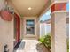 Inviting front entryway with stone flooring, large column, lush landscaping, and decor at 483 Cammarano Pl, The Villages, FL 32162