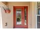 Close up of charming glass paneled front door with hanging planters and bronze colored hardware at 483 Cammarano Pl, The Villages, FL 32162