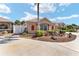 Beautiful front yard with mature landscaping, stone features, garden, and two-car garage at 483 Cammarano Pl, The Villages, FL 32162