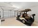 Spacious garage featuring a golf cart, white walls and ceiling with an automatic garage door at 483 Cammarano Pl, The Villages, FL 32162