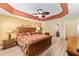 Main bedroom featuring a rattan bed frame, ceiling fan, and access to an ensuite bathroom at 483 Cammarano Pl, The Villages, FL 32162