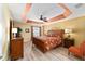 Comfortable main bedroom features a ceiling fan, decorative tray ceiling, and light-colored walls at 483 Cammarano Pl, The Villages, FL 32162