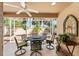 Enclosed patio area with a decorative dining set and ceiling fan for comfortable outdoor relaxation at 483 Cammarano Pl, The Villages, FL 32162