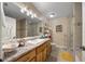 Clean bathroom with a single sink vanity, decorative lighting, and glass enclosed shower at 4940 County Road 134B, Wildwood, FL 34785