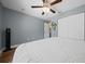 Bright bedroom with wood floors, a ceiling fan, closet space, and en-suite bathroom access at 4940 County Road 134B, Wildwood, FL 34785
