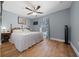 Bright bedroom features wood floors, a ceiling fan, and a large window at 4940 County Road 134B, Wildwood, FL 34785