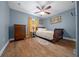 Cozy bedroom with a ceiling fan, wood floors, vintage dresser, and natural light from the window at 4940 County Road 134B, Wildwood, FL 34785