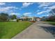 Charming home with a long driveway, detached garage, manicured lawn, and American flag at 4940 County Road 134B, Wildwood, FL 34785