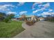 This single-story home boasts lush landscaping, an American flag, a curved sidewalk, and a detached garage at 4940 County Road 134B, Wildwood, FL 34785