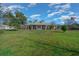 Expansive front lawn, with a beautiful home, dormer windows, and an American flag at 4940 County Road 134B, Wildwood, FL 34785