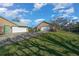 Exterior view of a detached garage with two bays, ample parking and landscaping at 4940 County Road 134B, Wildwood, FL 34785