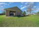 Detached garage featuring a roll up door, adjacent to a large manicured yard at 4940 County Road 134B, Wildwood, FL 34785
