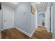 Well-lit hallway with wood floors connects rooms with white doors in this home at 4940 County Road 134B, Wildwood, FL 34785