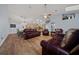 Spacious living room featuring leather furniture, wood floors, and a ceiling fan at 4940 County Road 134B, Wildwood, FL 34785