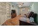 Cozy living room with wood flooring, custom built-in shelving, and a comfortable seating area at 4940 County Road 134B, Wildwood, FL 34785