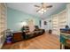 Inviting living room featuring hardwood floors, a ceiling fan, and custom built-in shelving at 4940 County Road 134B, Wildwood, FL 34785