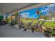 Relaxing covered patio with comfortable seating, lush potted plants, and scenic views of the backyard at 4940 County Road 134B, Wildwood, FL 34785