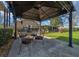 Charming patio with outdoor dining set, string lights, and views of the well-manicured backyard at 4940 County Road 134B, Wildwood, FL 34785