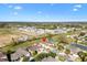 An aerial view showcasing a residential area with palm trees, green lawns, and well-maintained homes at 4982 Ne 124Th Rd, Oxford, FL 34484