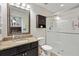 Well-lit bathroom featuring granite countertops, dark wood vanity, and a glass-enclosed shower at 4982 Ne 124Th Rd, Oxford, FL 34484