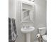 Powder room featuring a pedestal sink, decorative mirror and neutral decor at 4982 Ne 124Th Rd, Oxford, FL 34484