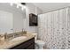 Well-lit bathroom featuring granite countertops, vanity, and a shower with a patterned curtain at 4982 Ne 124Th Rd, Oxford, FL 34484