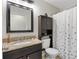 Bathroom features a granite sink and a shower with a curtain at 4982 Ne 124Th Rd, Oxford, FL 34484