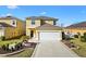 Two-story home featuring a two-car garage, manicured landscaping, and a welcoming entrance at 4982 Ne 124Th Rd, Oxford, FL 34484