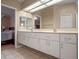 Bathroom featuring double sinks and great lighting, tile floor, and adjacent Primary bedroom at 5533 Squires Dr, Leesburg, FL 34748