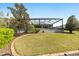 The backyard of the home features a large yard, screened pool, and tidy landscaping at 589 Society Hill Cir, The Villages, FL 32162