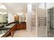 Bathroom featuring double sinks, a walk-in shower, and a towel warmer at 589 Society Hill Cir, The Villages, FL 32162