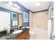 Bathroom with navy blue walls, a granite-topped vanity, and a shower-tub combo at 589 Society Hill Cir, The Villages, FL 32162